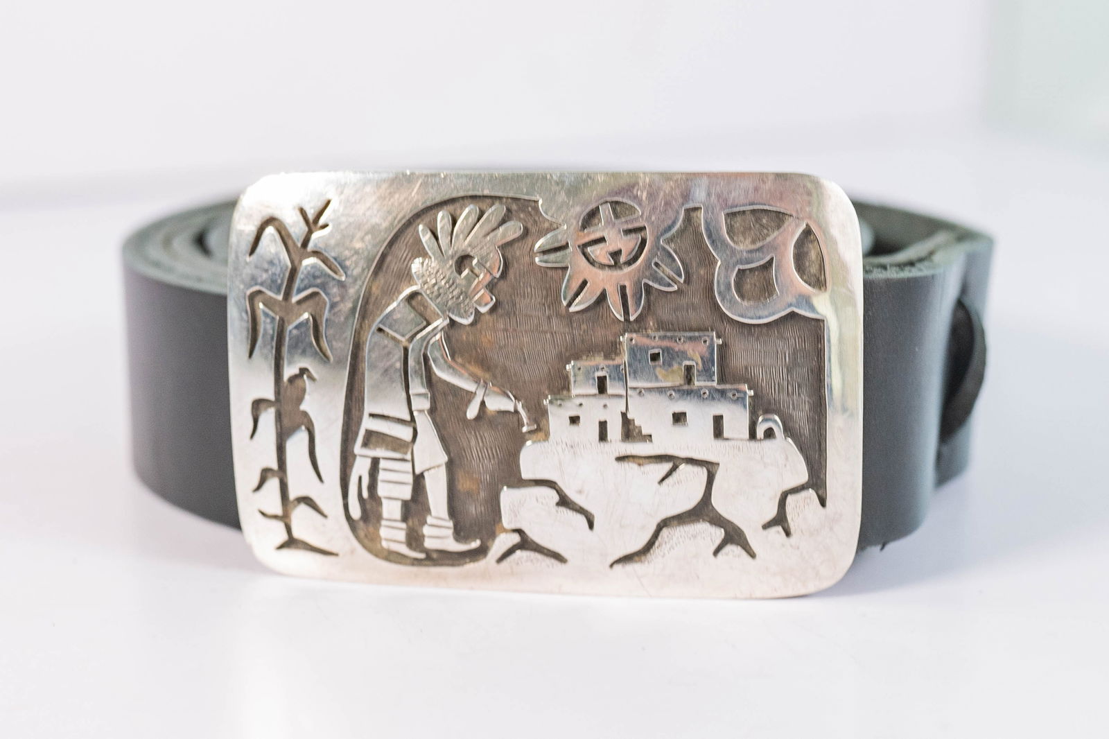 Vintage Hopi Overlay Belt Buckle: Native American Hopi vintage sterling silver with intricately detailed hand tooled overlay design with a bird sitting on a corn husk a Kachina dancer and sun and clouds.the black leather strap is an