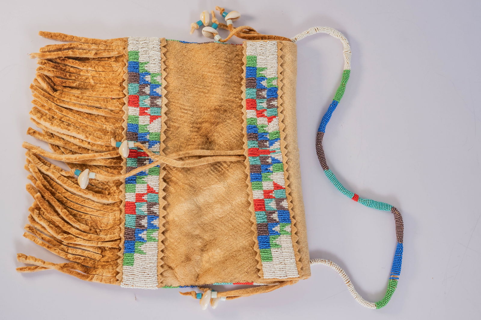 Vintage Sioux Beaded Bag: Native American Sioux Vintage Circa 1900s Beaded Bag with amazing intricate bead work on bag and handle with seashell accents. Length 10 1/2 " width 9" beaded strap 20"