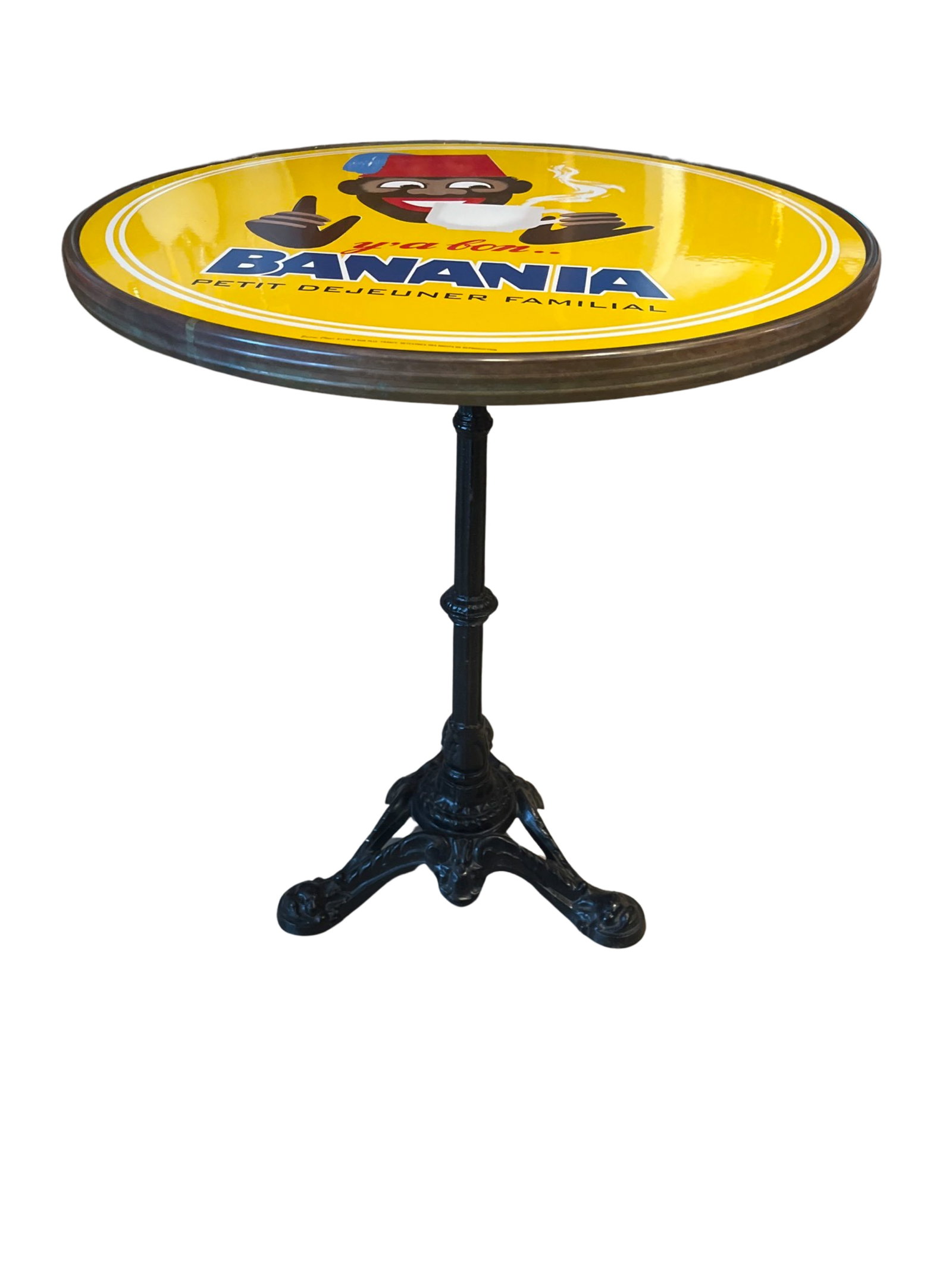 Banania Iron Table with Enamel top (Reproduction): This enameled bistro table features a vintage advertisement for Banania. A modernized version of the tirailleur made in 1959 by Herv é Morvan. A popular product for over a century, This is a great pi