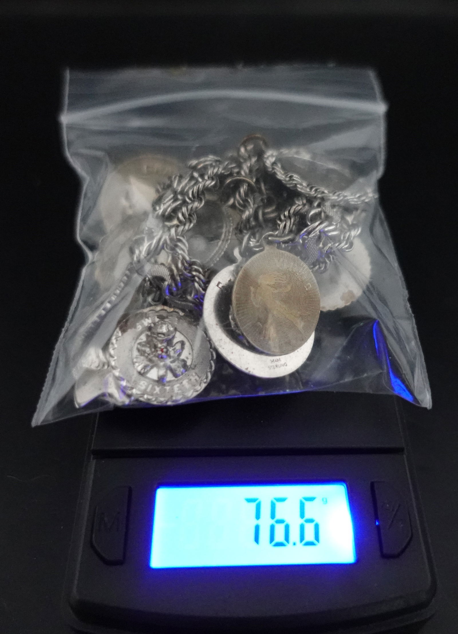 Sterling Silver Charm Bracelet with Charms: This weighs 76.6g of Sterling silver with 12 Charms. Gorgeous Bracelet. Most of the Charms have the Sterling Stamped on them. Low Estimate: 200 High Estimate: 240