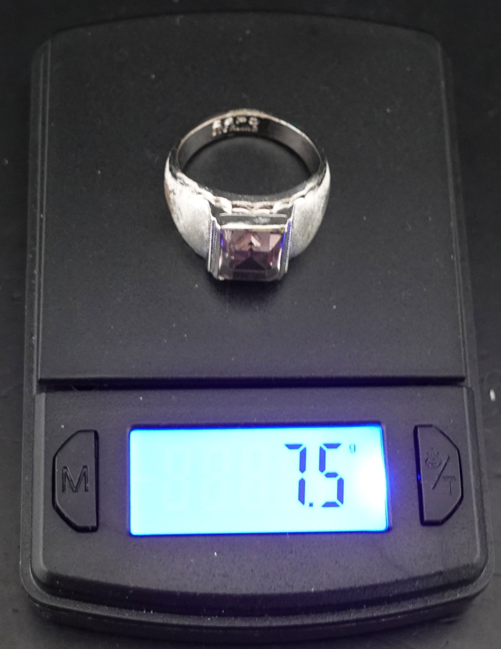 Silver and Amethyst Ring: The Weight is 7.5g of Sterling Silver. It is Marked as Sterling. The Gem Appears to be Amethyst. Looks to be Size 8 Low Estimate: 30.00High Estimate: 50.00