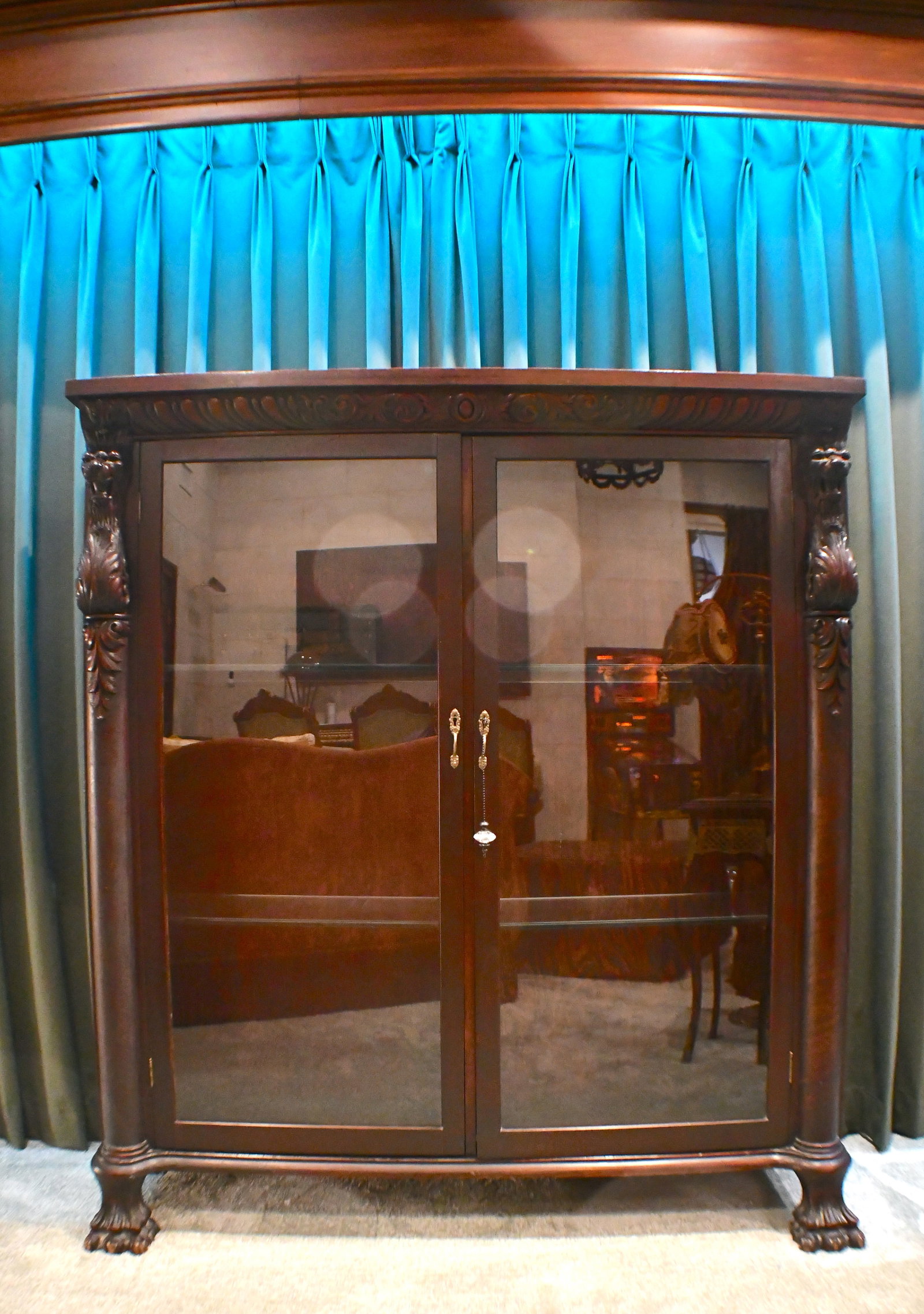 Large Wooden and Glass Fronted Cabinet: Large mahogany wood with glass cabinet that has two glass shelves Has Cat-like carvings on feet and sides of cabinet Has Key with Crystal Fob No Markings of manufacturer 62" tall x 56" wide x 18" deep