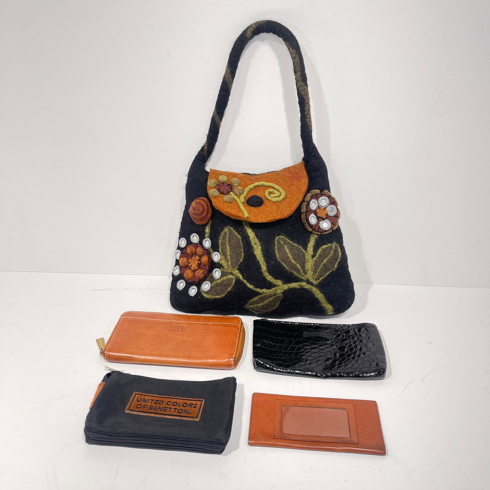 A Group of Four Wallets: A Group of Four Leather, Faux Leather and Canvas Wallets, Two having genuine leather. Together with a 100% felted wool handbag. Handbag dimensions: H: 11 x W: 12 1/2 in.