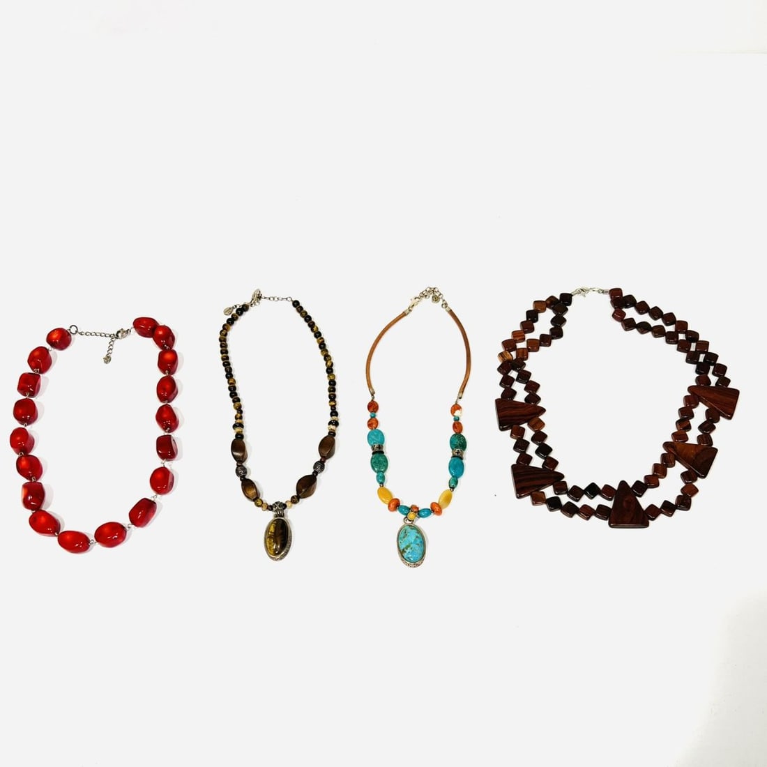 Four Silver, Coral, Wood and Natural Stone Necklaces,: A Group of Four Silver, Coral, Wood and Natural Stone Necklaces, Comprising of one tigers eye, one turquoise, one coral, and one wood necklace with 925 Sterling details. Dimensions: From a private NE 