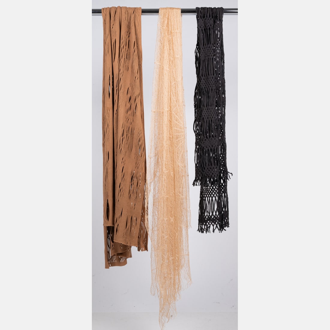 Three Open-Weave Scarves: Three Open-Weave Scarves, A medium tan colored knit scarf with an open weave pattern. No label or fabric content tag; feels like cotton. Dimensions: 24 x 74 in. A lightweight, light tan colored scarf