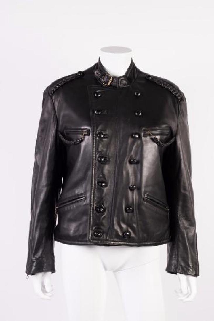 DKNY: Blouson en cuir noir, col motard, fermeture par deux rang de boutons ronds en cuir, quatre poches Zippées dont deux poitrines les zip retenu par des tresses de cuir. Deux tresses de cuir aux épaules