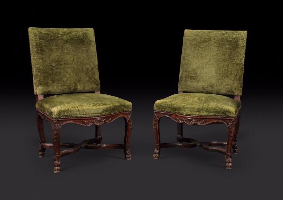 Paire de chaises en chêne teinté à dossier carré,: Paire de chaises en chêne teinté à dossier carré, sculptées de coquilles et feuillages ; reposant sur des pieds cambrés réunis par une entretoise. Epoque Louis XV. Restaurations. H : 96 cm, L :