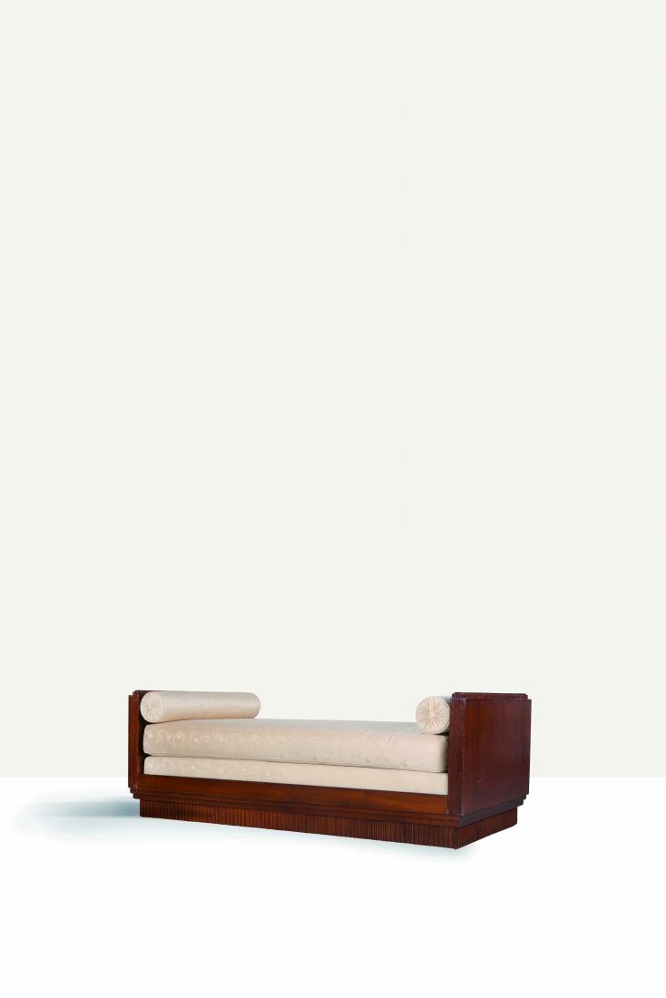 CHRISTIAN KRASS (1868-1957) Banquette en placage de: CHRISTIAN KRASS (1868-1957) Banquette en placage de palissandre a? te?te et pied de lit quadrangulaire a? frise crante?e en partie haute et pie?tement plein e?galement crante?. Lit et e?dredons recouv