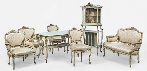 Mobilier de salon en bois laqué crème sculpté et: Mobilier de salon en bois laqué crème sculpté et ajouré de feuillages composé de deux larges fauteuils, deux chaises, une banquette et une vitrine.