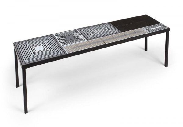 "Roger CAPRON (Né en 1922)Grande table basse à p: "Roger CAPRON (Né en 1922)Grande table basse à plateau rectangulaire à motif géométrique en reliefdans les tons gris blanc et noir reposant sur qautre pieds en acier laqué.39 x 120 x 31 cm.Circa