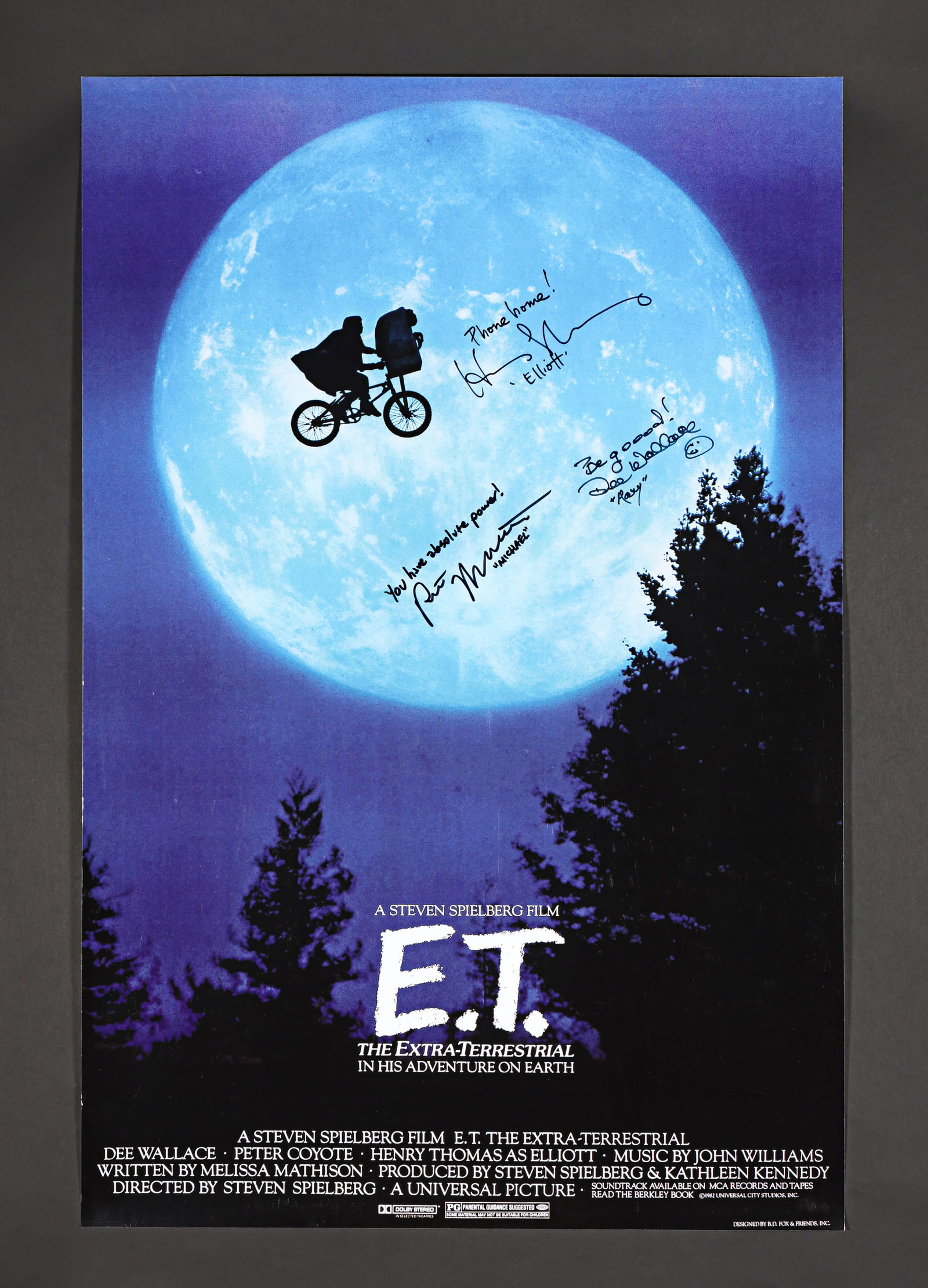 E.T. THE EXTRA-TERRESTRIAL (1982) - Henry Thomas, Dee Wallace and Robert MacNaughton Autographed and: A poster for Steven Spielberg's E.T. The Extra-Terrestrial (1982) featuring the iconic "bike over the moon" imagery. It is autographed in black ink by Henry Thomas (Elliott Taylor), inscribed "Phone h