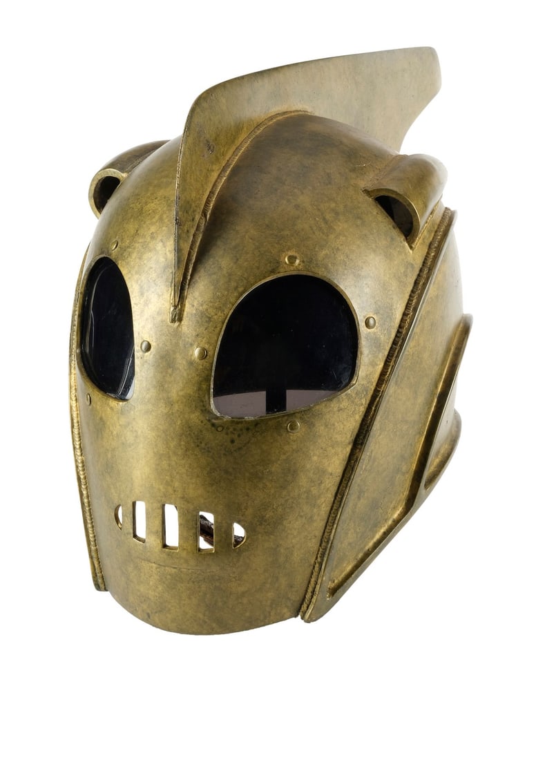 THE ROCKETEER (1991) - Disney Theme Park Rocketeer Helmet: THE ROCKETEER (1991) - Disney Theme Park Rocketeer Helmet - A Rocketeer helmet created by Disney with direct lineage to the production originals from Joe Johnston's The Rocketeer. In The Rocketeer, pi