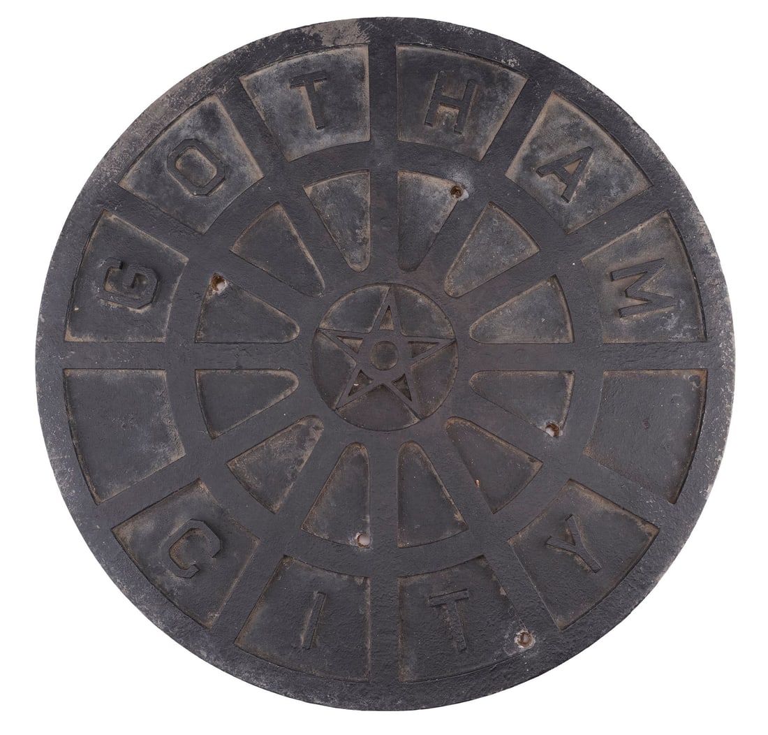 BATMAN BEGINS (2005) - Gotham City Manhole Cover: BATMAN BEGINS (2005) - Gotham City Manhole Cover - A Gotham City manhole cover from Christopher Nolan's Batman Begins. Manhole covers lined the streets of Gotham City as the Scarecrow (Cillian Murphy)