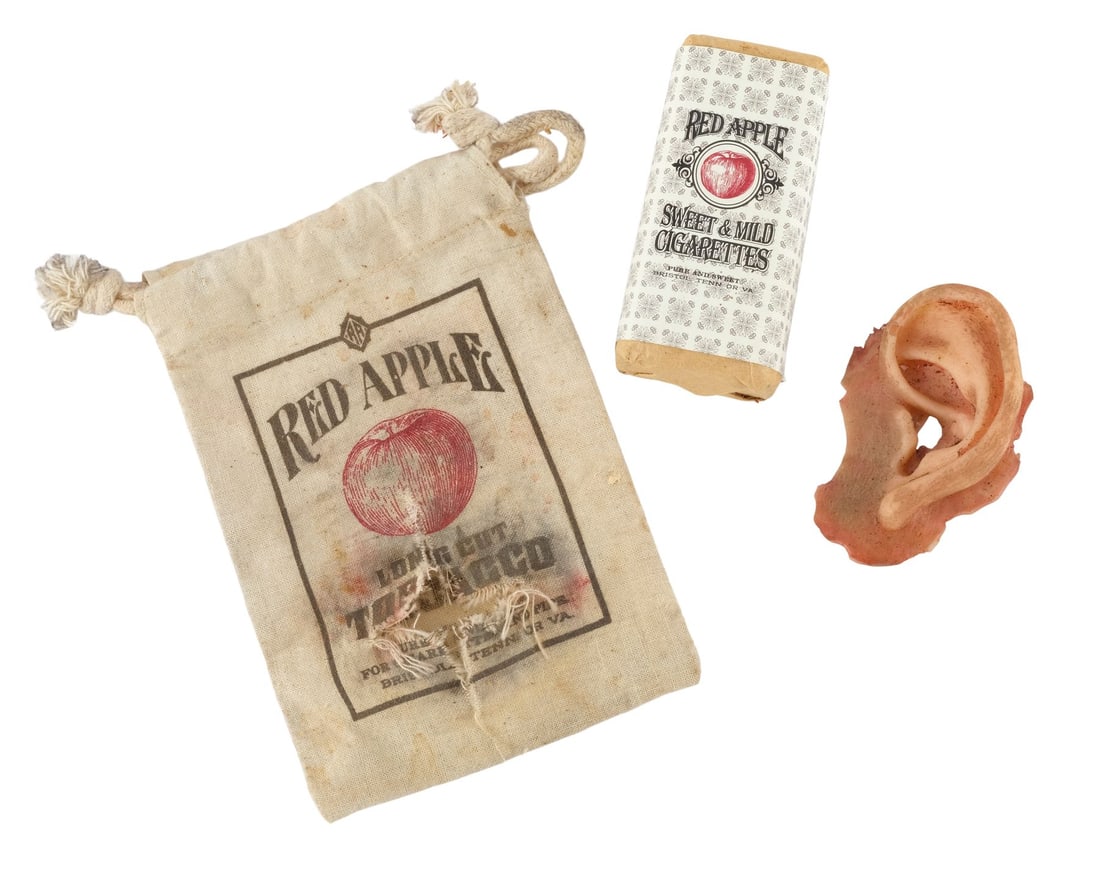 DJANGO UNCHAINED (2012) - Red Apple Cigarettes, a Tobacco Bag, and a Severed Silicone Ear: DJANGO UNCHAINED (2012) - Red Apple Cigarettes, a Tobacco Bag, and a Severed Silicone Ear - Red Apple Cigarettes, a tobacco bag, and a severed silicone ear from Quentin Tarantino's Django Unchained.