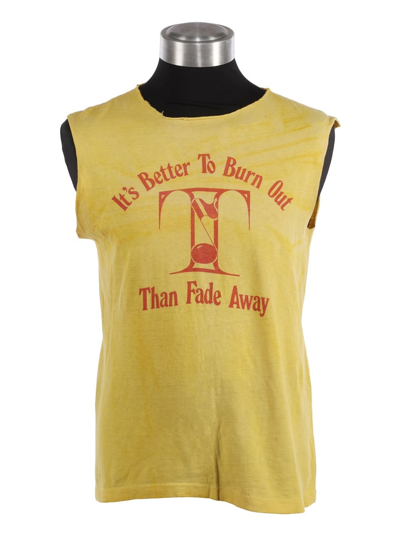 DEF LEPPARD - Joe Elliot, Steve Clark, and Rick Allen-Autographed T-Shirt, Worn In The Rock of Ages: DEF LEPPARD - Joe Elliot, Steve Clark, and Rick Allen-Autographed T-Shirt, Worn In The Rock of Ages Music Video, 1983 A yellow sleeveless T-shirt worn by Joe Elliott in the music video for Def Leppard