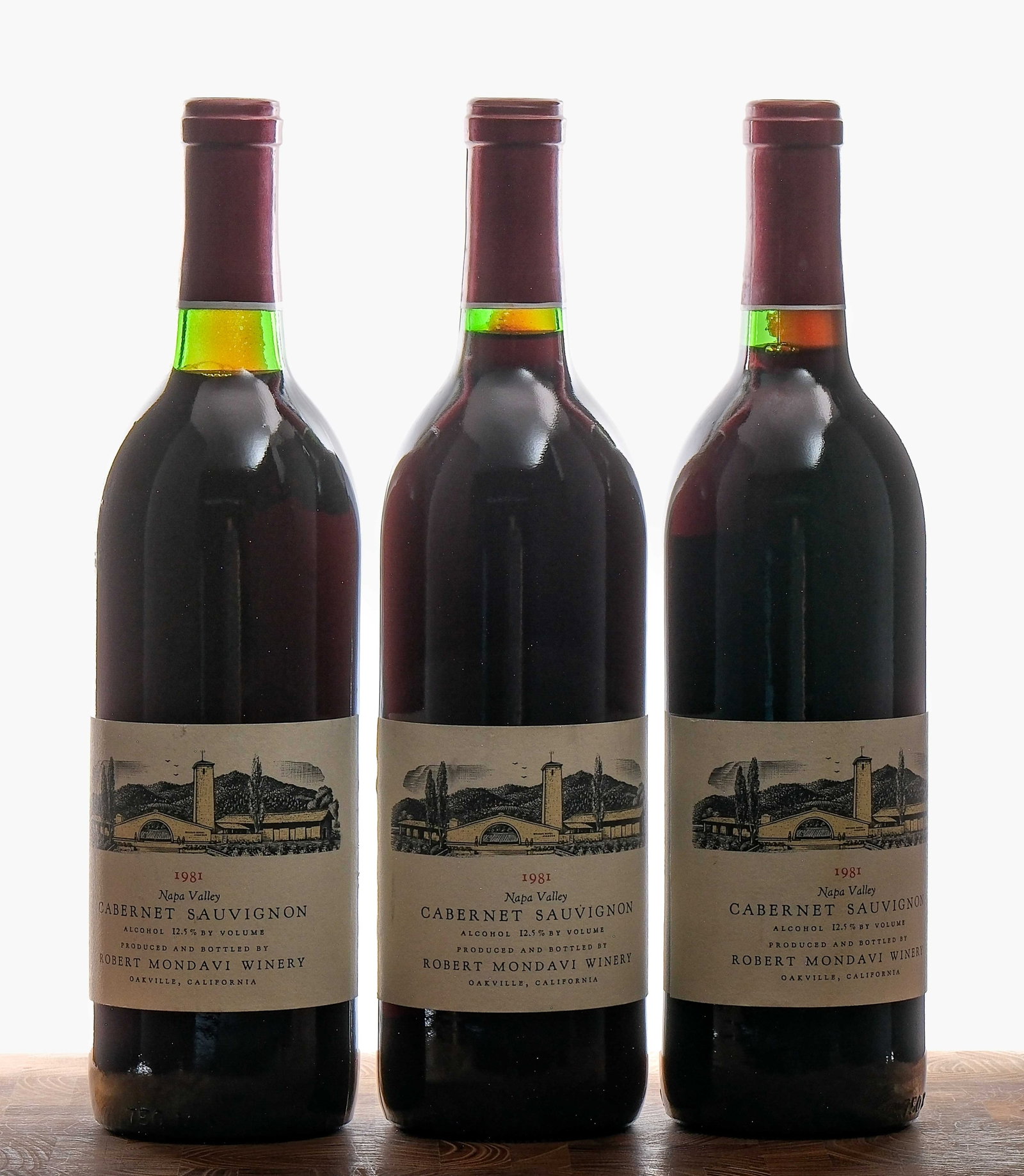 Robert Mondavi Cabernet Sauvignon 1981 Group (3): Group of 3 bottles with a 1981 vintage. Fill levels are mid-neck on two of the bottles and base neck on the third. Heavy sediment on two of the necks. 12.5% ALC/VOL. Foils are very good (only slight c