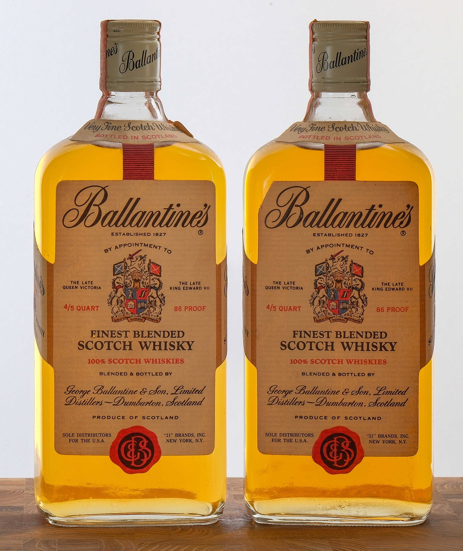 Ballantine's 86 Proof Blended Scotch Vintage Group (2): 2x bottles. 43% ALC/VOL. Screw tops and bottle stamps intact. Labels generally excellent (those affixed at the neck of the bottle exhibit some lifting and dog-earing at the corners). 4/5 Qt. George Ba