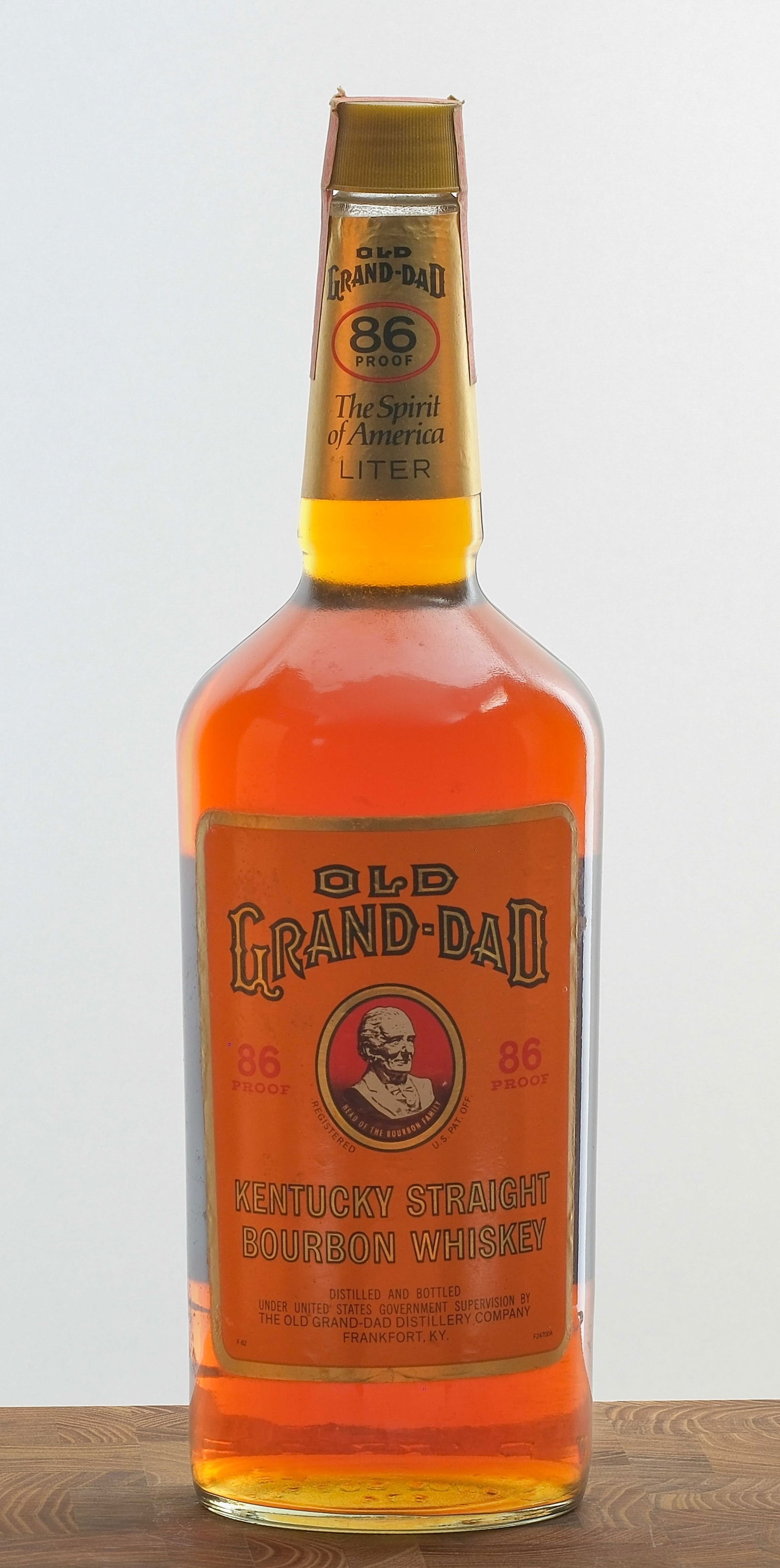 Old Grand-Dad Kentucky Straight Bourbon Whiskey: 43% ALC/VOL (86 Proof). Bottle stamp intact. Labels excellent given its age, with only a few nicks and dings throughout. 1 Liter. The Old Grand-Dad Distillery.