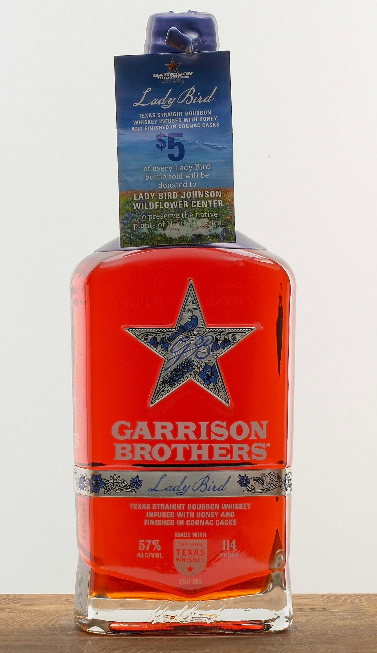 Garrison Brothers "Lady Bird" Texas Bourbon 2023: Texas straight Bourbon Whiskey infused with honey and finished in Cognac casks. Bottle #4,808. 57% ALC/VOL (114 Proof). Wax seal intact. Hang tag (containing a packet of wildflower seeds) intact. Labe