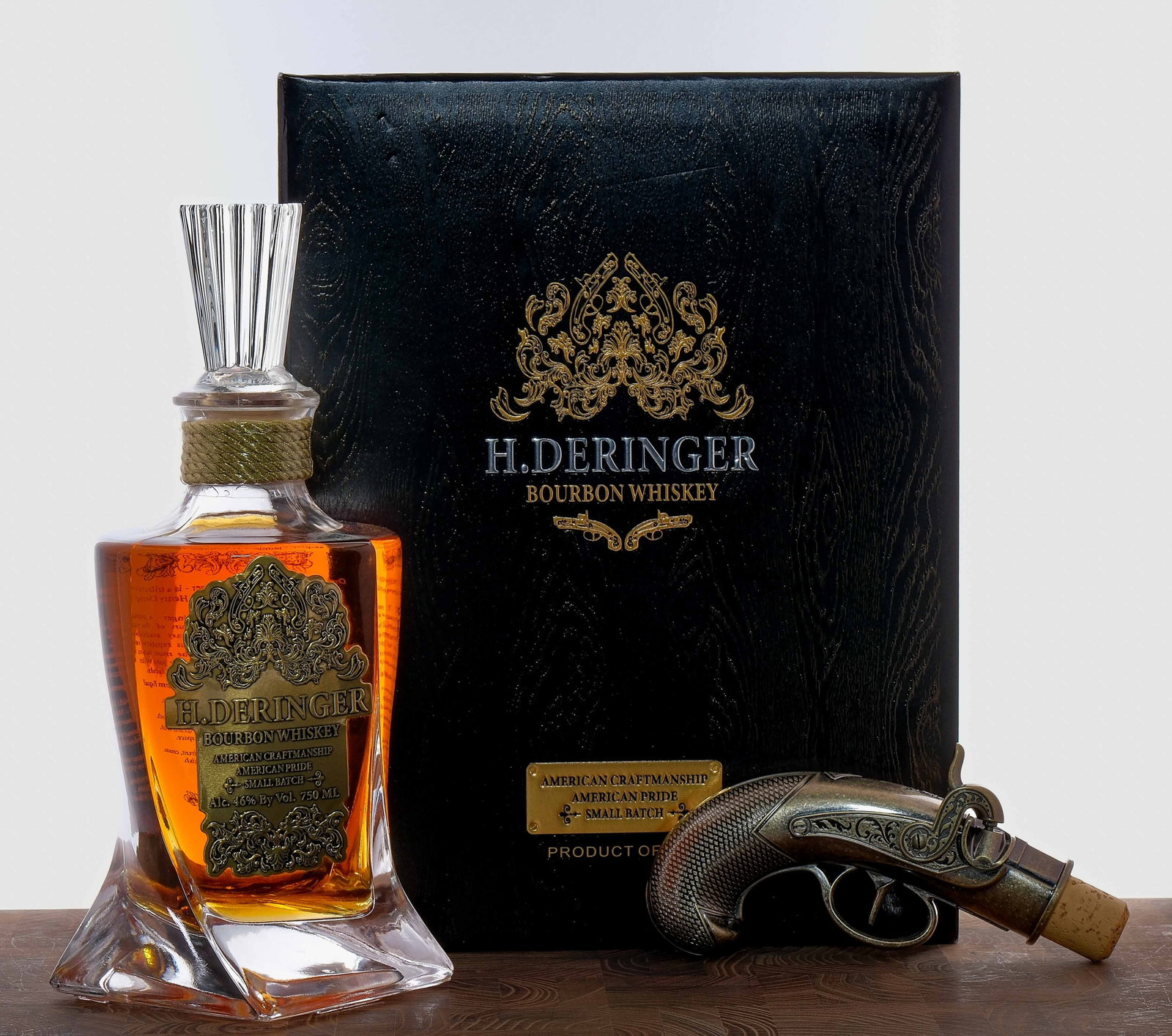 H. Deringer Small Batch Bourbon: 46% ALC/VOL (92 Proof). Original presentation box largely excellent (some cosmetic defects like scuffs, nicks and dings are present throughout). Includes Deringer gun inspired bottle stop. Plastic sea