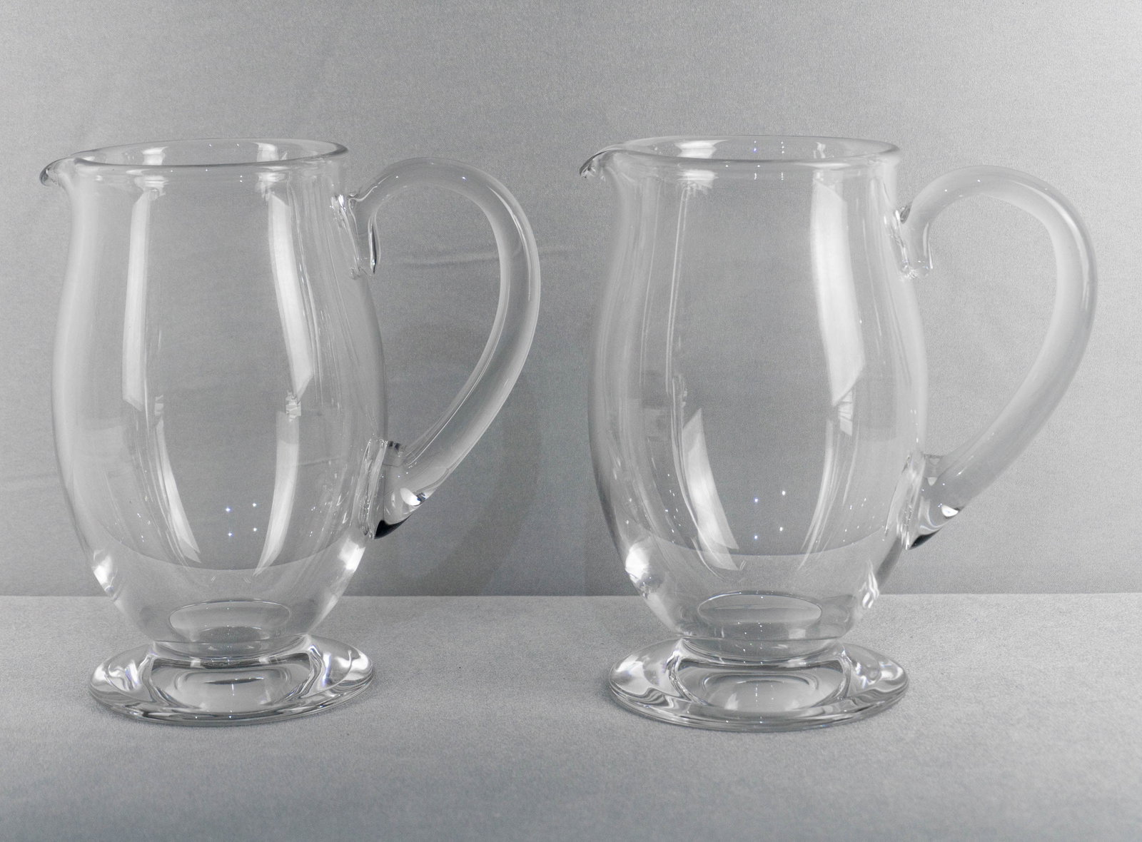 PAIR BACCARAT WATER PTCHERS: A pair of elegant Baccarat pitchers each measures, 7.5 in H x 7 in H / 19cm H x 18cm W Shipping: Shipping costs are not included but both international and national shipping quotes are available using