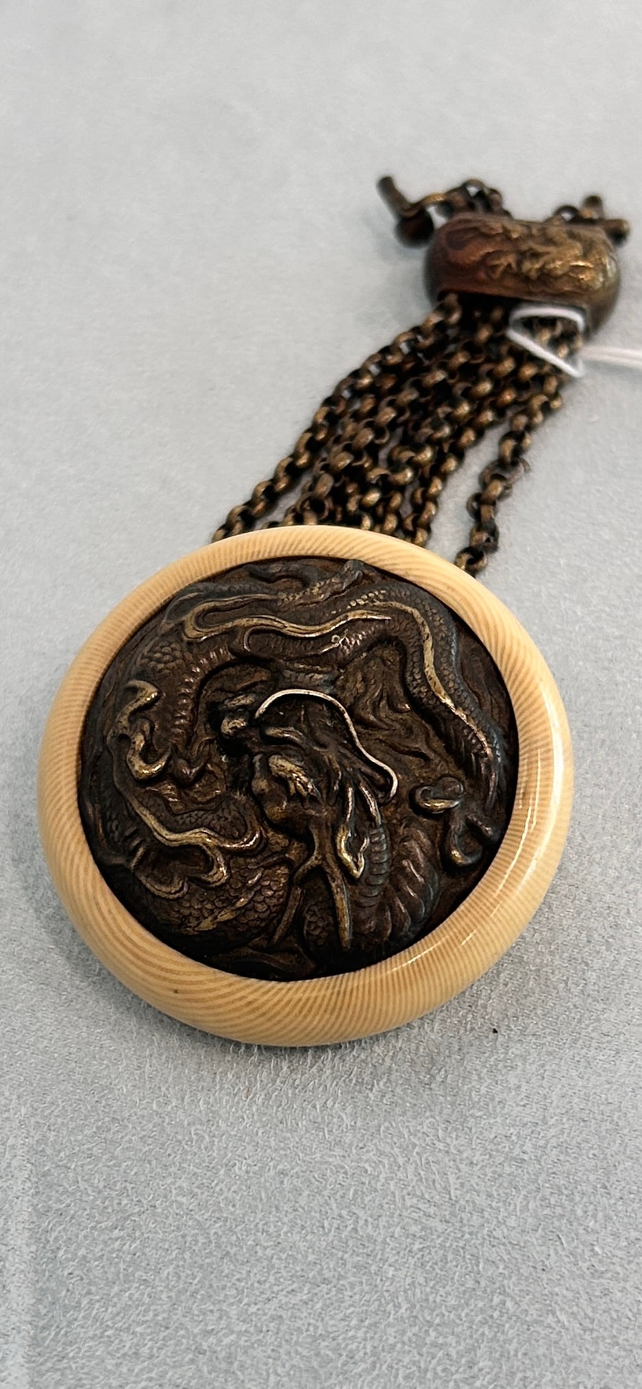 Meiji Period Japanese Button w/Bronze Dragon Motif: Meiji Period Japanese Button with Bronze Dragon Motif 2 Dia 5 L inches Our Winter Sale takes place ONLINE ONLY, Sunday January 26th 2025 at 11 AM EST. Registration is open now and during the sale. In-