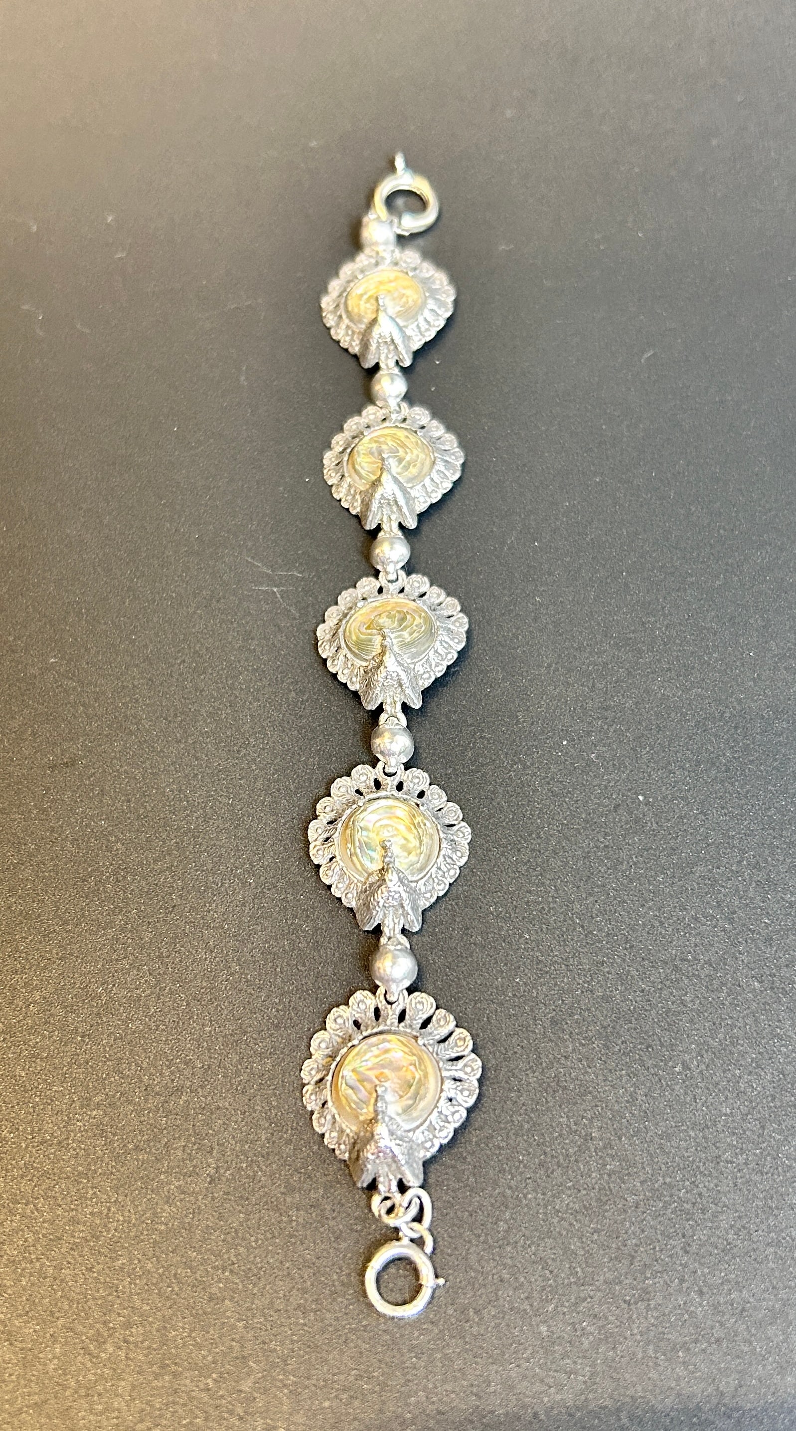Vintage Sterling Abalone Peacock Bracelet: Vintage Sterling Abalone Peacock Bracelet marked sterling 7.5 inches long CONDITION: Good Join us online for Long Lake Art and Antique's Spring Sale, June 1st, 2025, 11 AM EST.