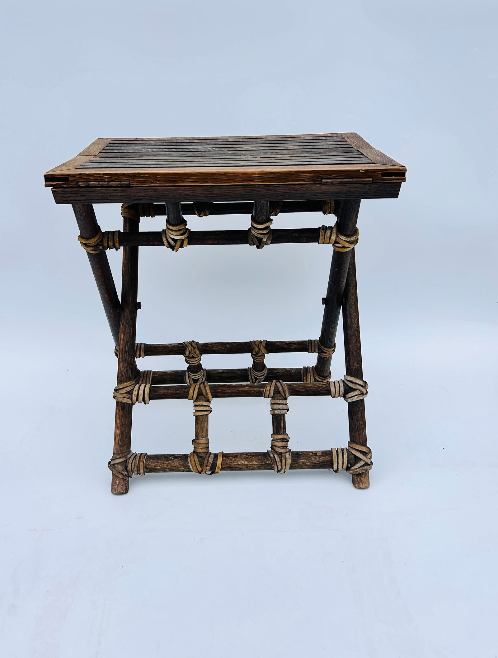 MCGUIRE CAMPAIGN FOLDING PINCH FINGER: VINTAGE MCGUIRE CAMPAIGN FOLDING PINCH FINGER TABLE, RATTAN, OAK AND LEATHER. Measures: &nbs