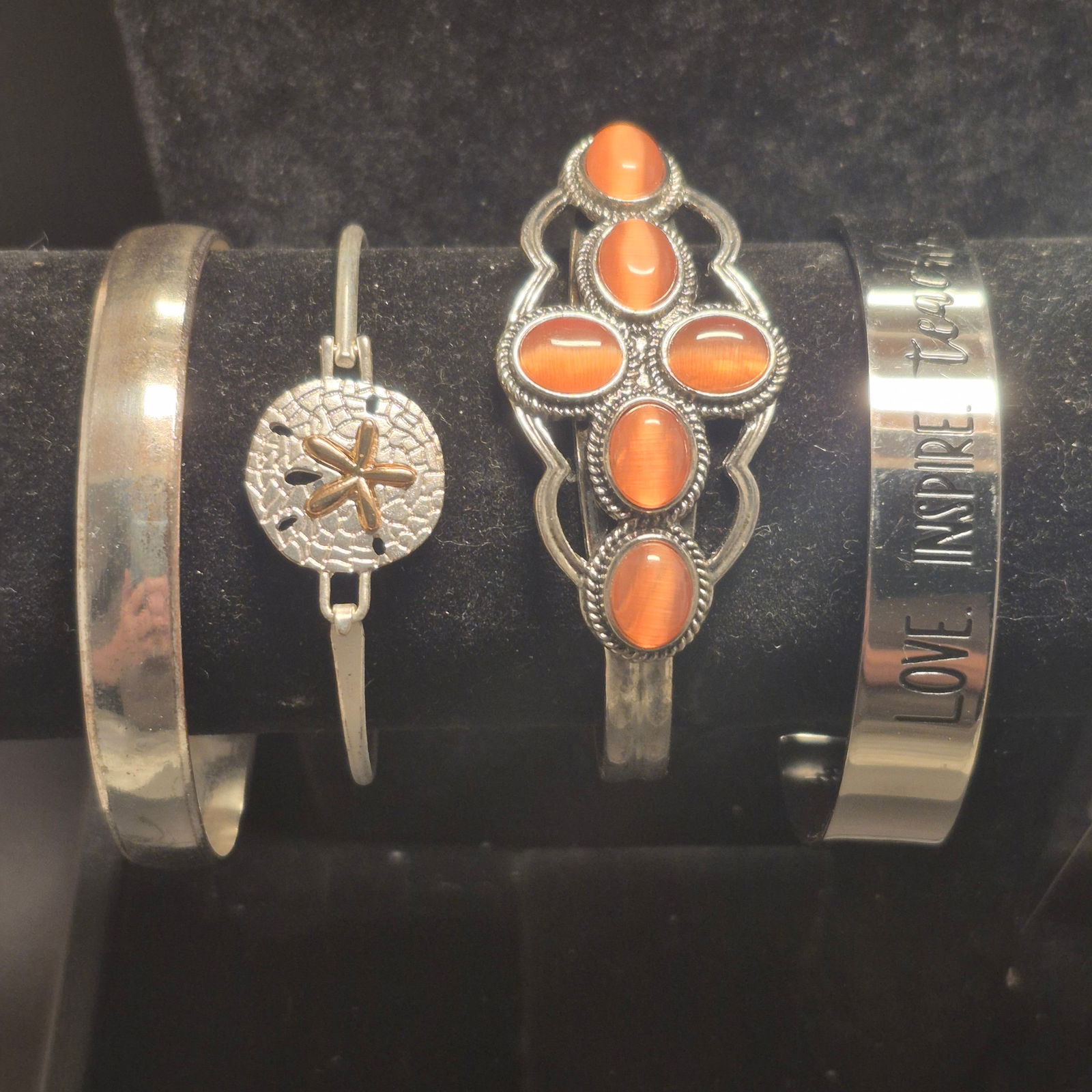 Fashionable steel BRACELETS: 4 set ~ cuff styles: Fashionable steel BRACELETS: 4 set ~ cuff style> orange glass set in steel> sand dollar with open clip style> religious cuff...inscriptions in and out> solid cuff steel great shineVG condition all
