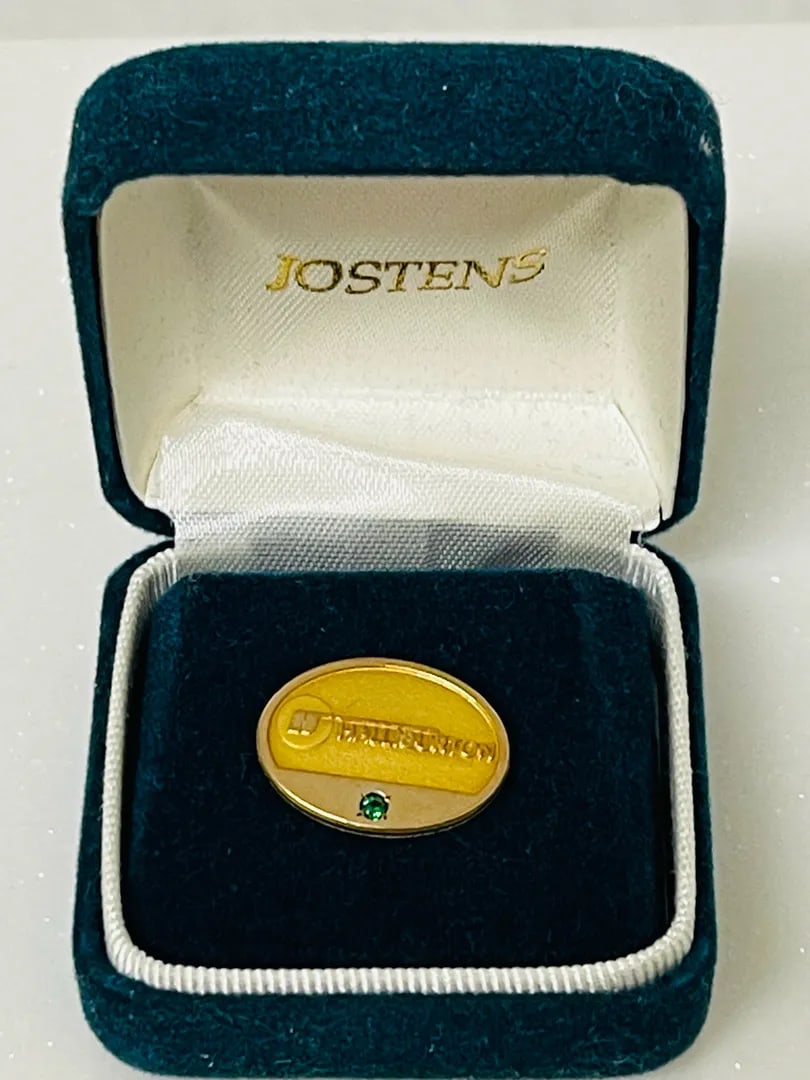 Jostens for Halliburton 10KGF Lapel Pin ~ 2.65g: A polished Jostens for Halliburton oval lapel pin in 10K gold filled finish with a green accent stone, complete with interchangeable clutch backs, one with attached safety chain, for versatile wear.St