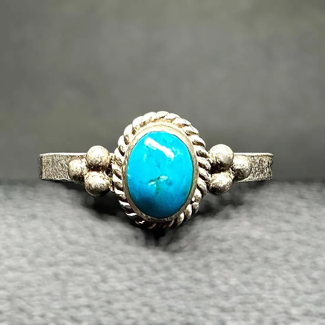 Native American Sterling Silver Turquoise Sz5.75/1.3g: one delicate ring set with an oval turquoise cabochon in a twisted rope bezel with bead accents; Overall good vintage condition with light surface wear, minor scratches, and tarnish consistent with ag