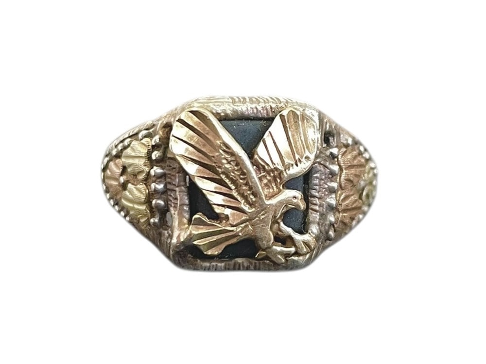 BLACK HILLS GOLD & STERLING EAGLE MENS RING: Black Hills Gold Eagle Ring, Sterling SilverA men's pinky ring featuring a gold appliqued eagle on the black onyx center, as well as gold leaves on the sides. The ring itself is sterling silver and ma