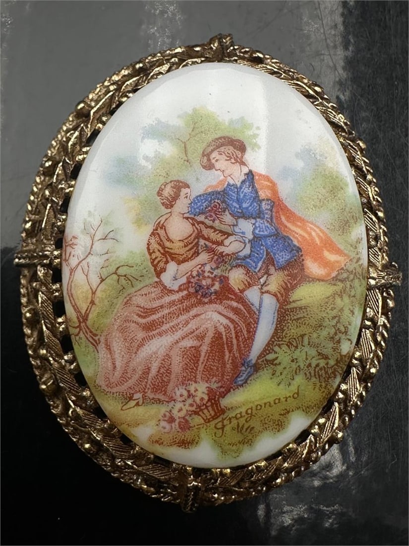 Vintage Fragonard Porcelain Brooch Pendant: Vintage Fragonard scenic porcelain brooch pendant featuring a romantic Rococo courtship scene in ornate gold-tone filigree frame. Convertible brooch and pendant design with detailed openwork backing a