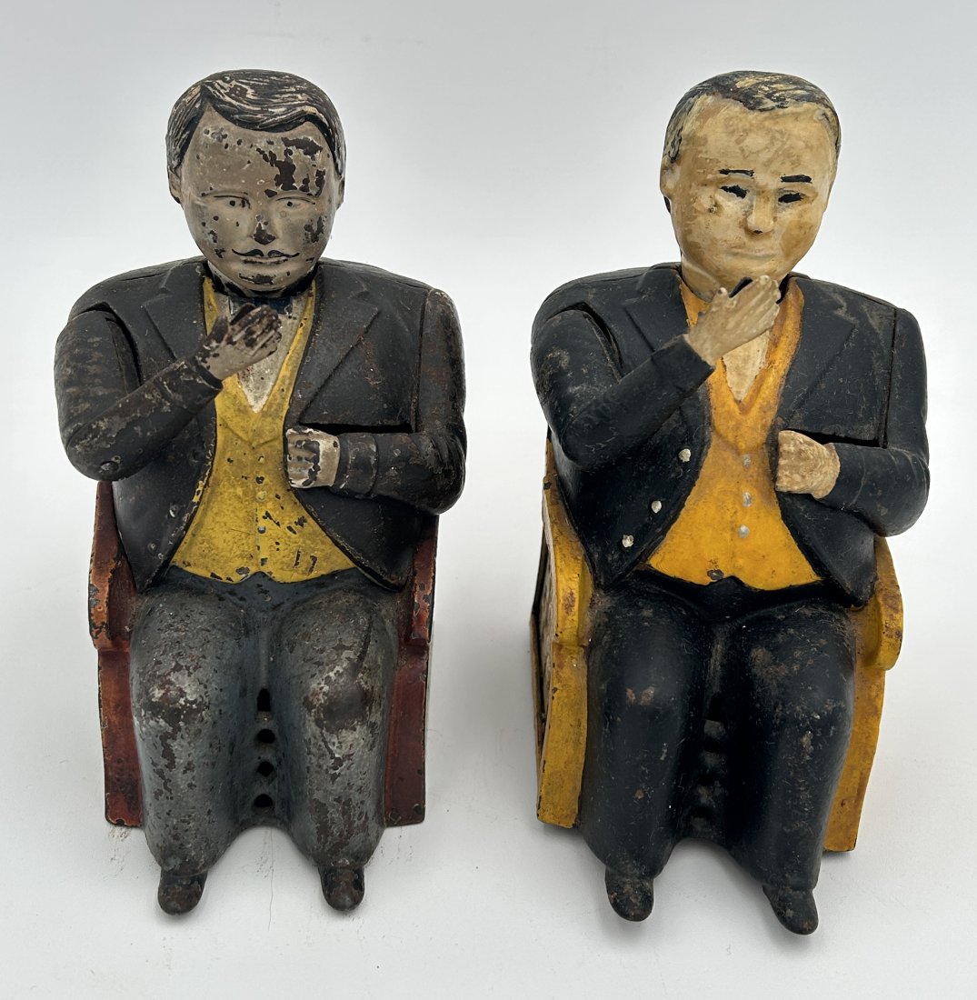 Pair of Antique J. E. Stevens Cast Iron 'Tammany Man' Mechanical Banks: Both are operational, with original paint [came in multiple finishes]. Placing a penny in his hand causes his arm to swing into his briefcase, followed by a nod of recognition. A nod to the rampant co