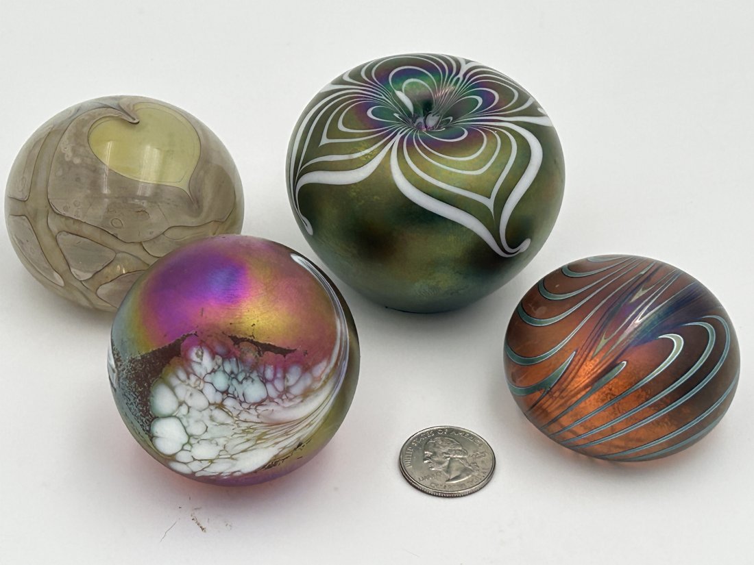 Grouping of 4 Vintage Art Glass Paperweights: A variety of vintage paperweights, including heart in hand, iridescent and figural apple with pulled feather design. Several are signed.