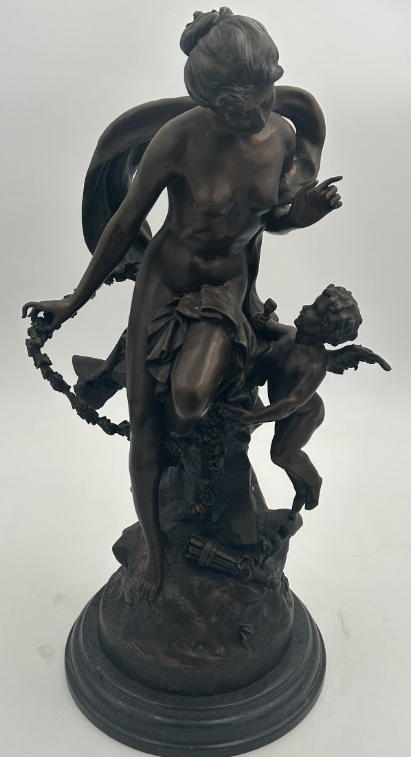 Large After Mathurin Moreau bronze Sculpture of Venus with Cupid: A large sculpt, standing over 22" in height, a Neo-classical rendition of a seated Venus with Cupid. Posthumous Mathurin Moreau signature on base of sculpt. Set atop a black marble base.
