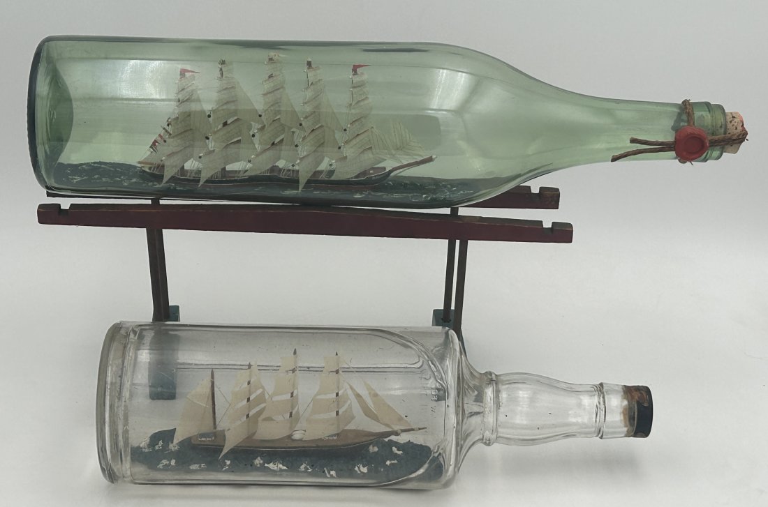 2 Large Vintage Ship in a Bottle Models: Both are very fine examples, quite detailed, with frothing seas and large clipper ships. Longer measures 19.5". Condition is very good.