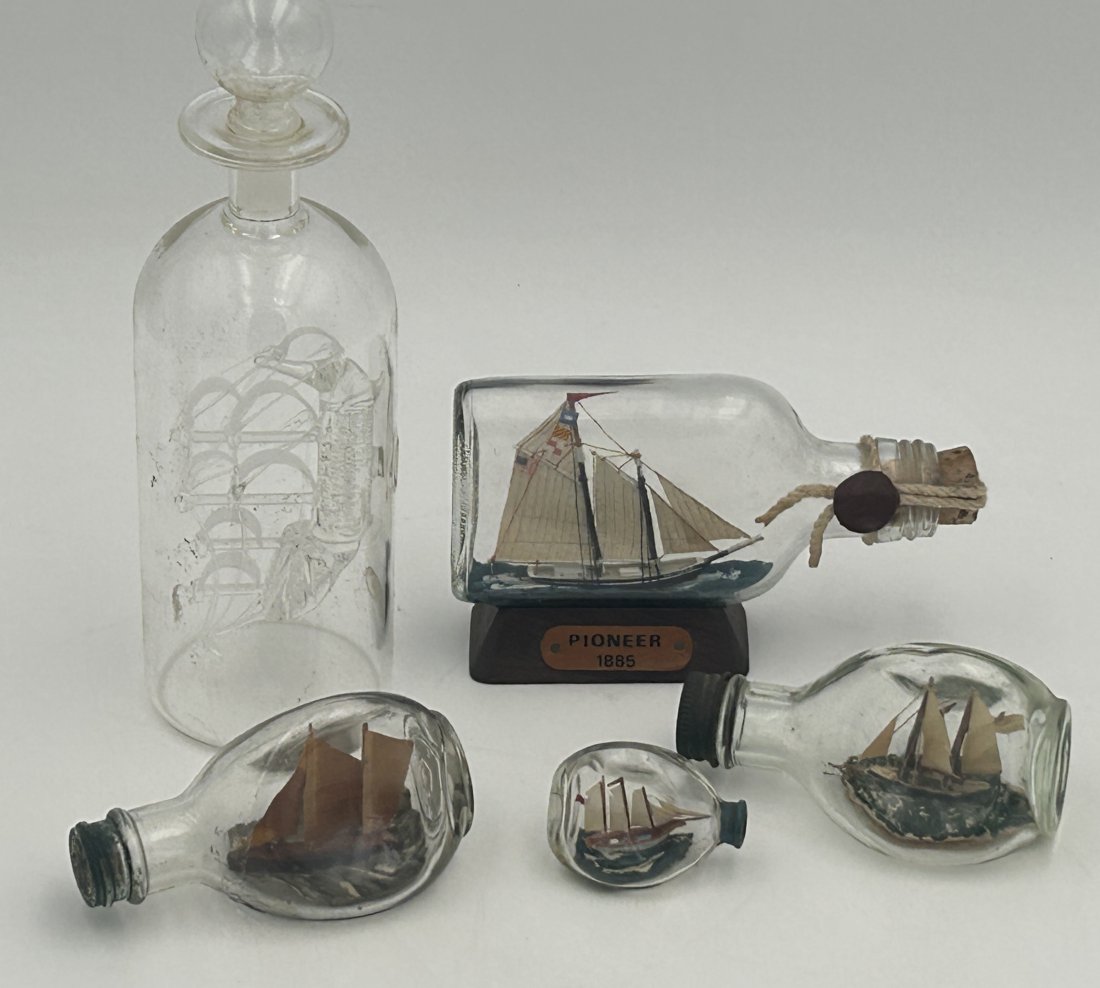4 Vintage Diminutive Ship in a Bottle Models plus Blown Glass Clipper Ship Decanter: All are in good condition, finely detailed despite smaller scale. Longest measures only 5.5" in length. Also included, a blow glass decanter with a clipper ship within the well.