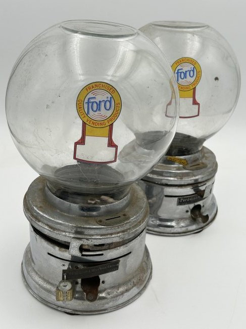 Vintage circa 1950s Coin-Operated FORD Penny Gumball Machines: Glass-bubble domed penny gumball machines by Ford, dating to the 1950s. Both look to be complete [1 has a key], but are not tested and being offered as shown. 13" in height.