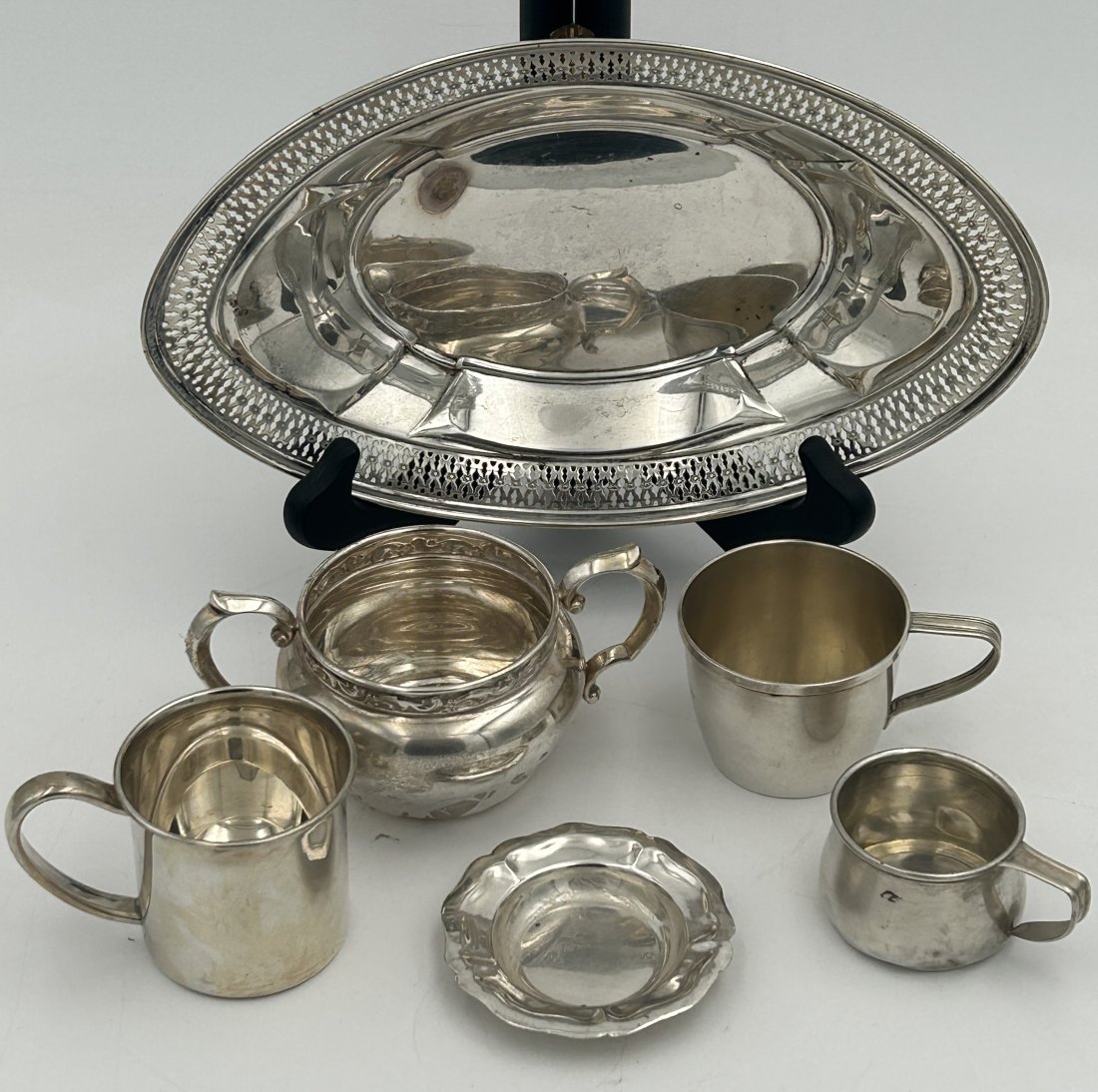 6 Piece Mixed Sterling Silver Lot: Includes a reticulated charger, creamer, diminutive plate, and several baby cups. 13.21 troy ounces in total.