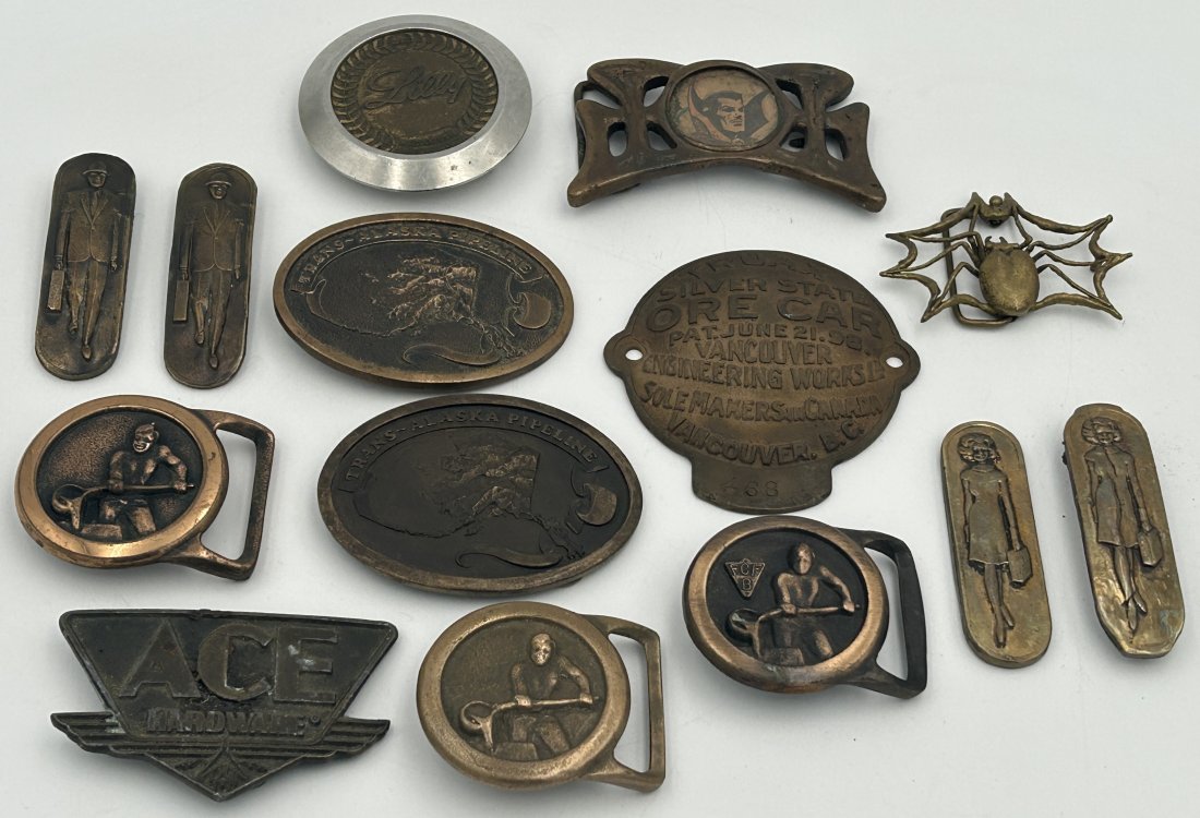 Vintage Belt Buckles and Placards: A mixed grouping of vintage belt buckles, as well as other small metal objects.
