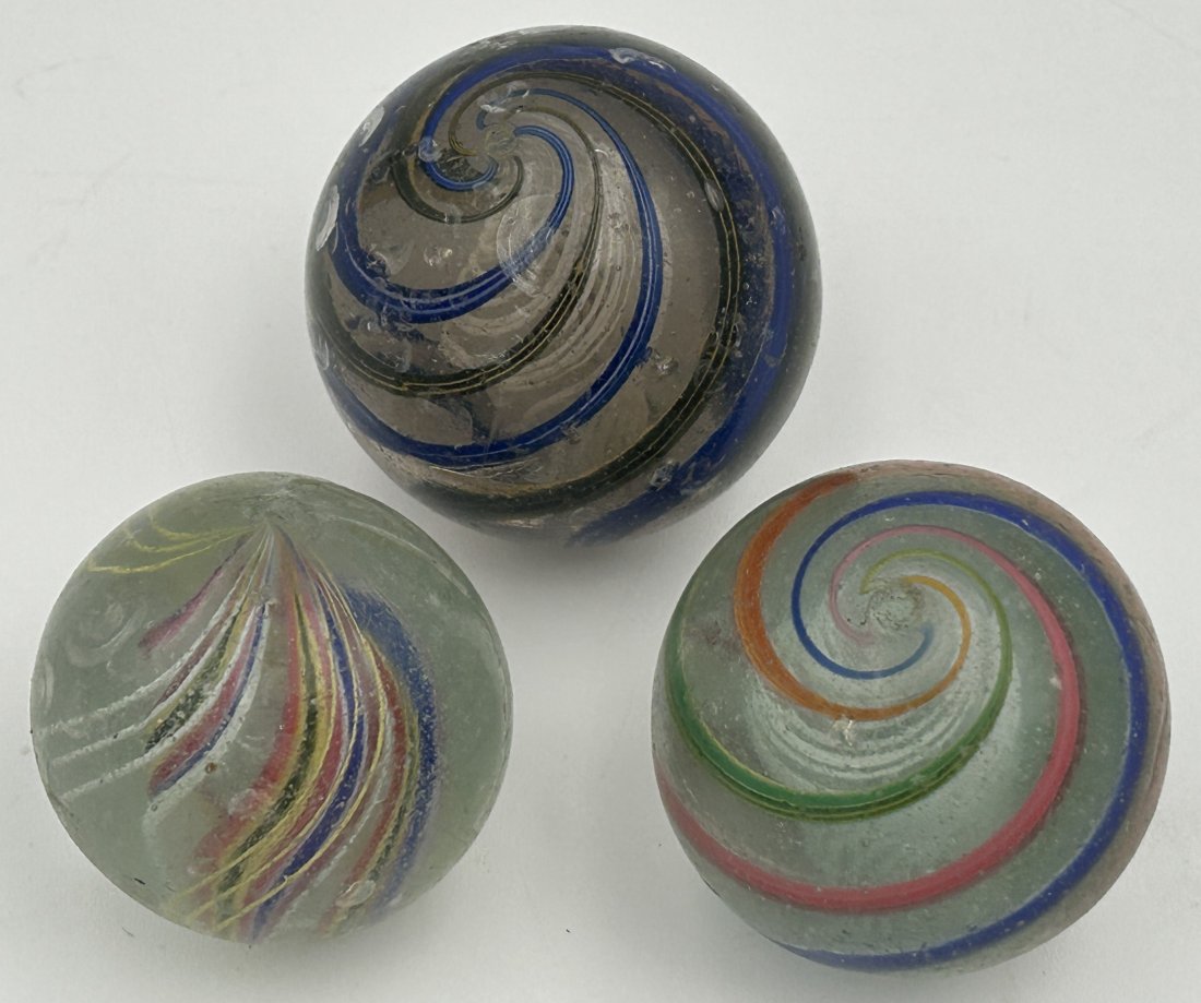 3 Antique 19th Century Hand-Blown German Marbles: All are hand-blown, with visible pontils. Bigger examples, referred to as 'shooters'. Largest measures just over 2" in diameter.