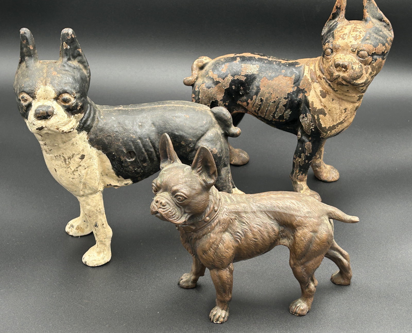 3 vintage French bulldog doorstops: 2 larger examples, in the vein of period Hubley [possibly Hubley], one with good paint and the other with finish wear. also, a copper Jennings Brothers from the 1930s.