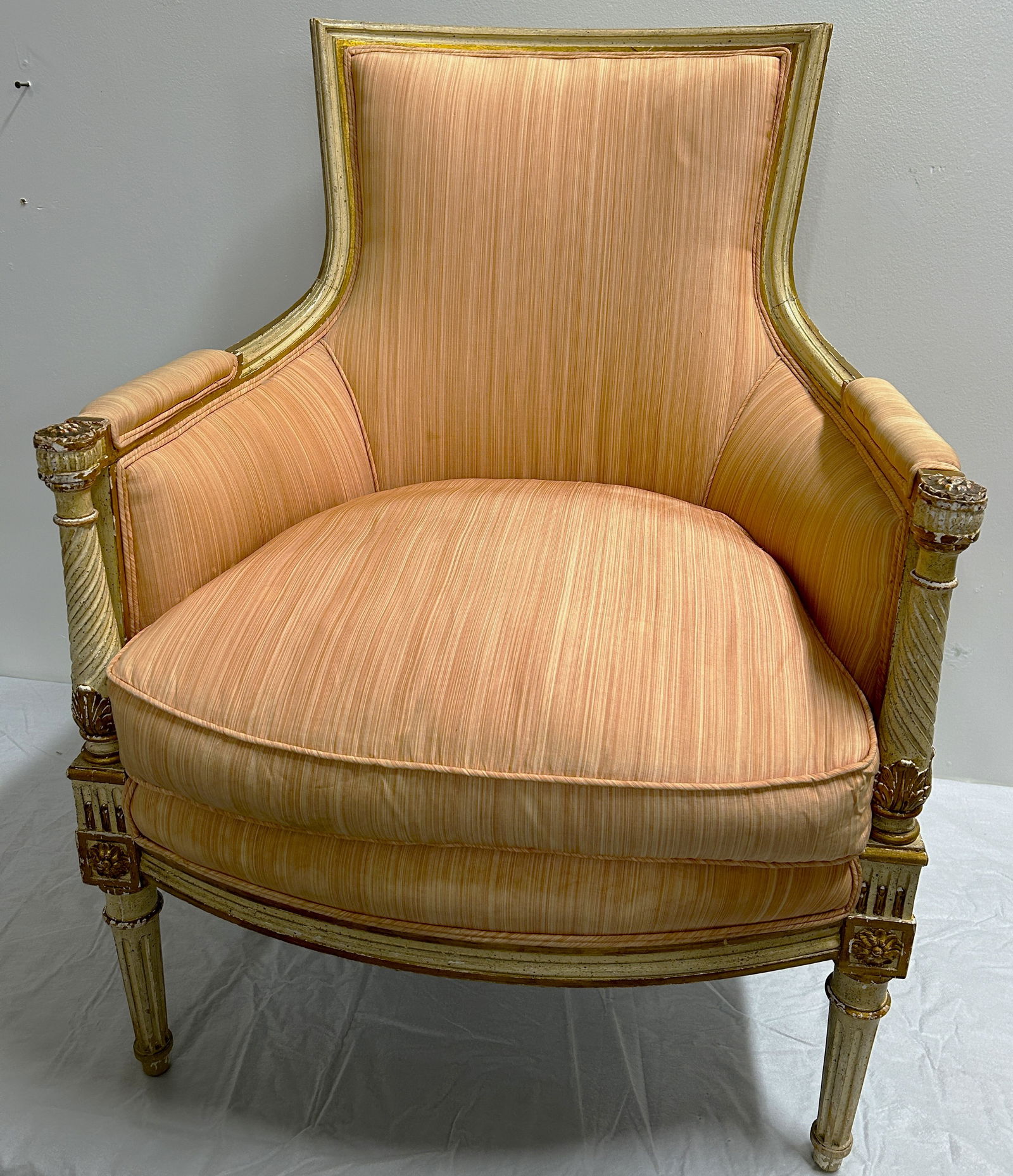 Louis VXI Bergere Armchair: Circa 1860, with peach color upholstery and painted frame. Measures 37" by 27" by 24".