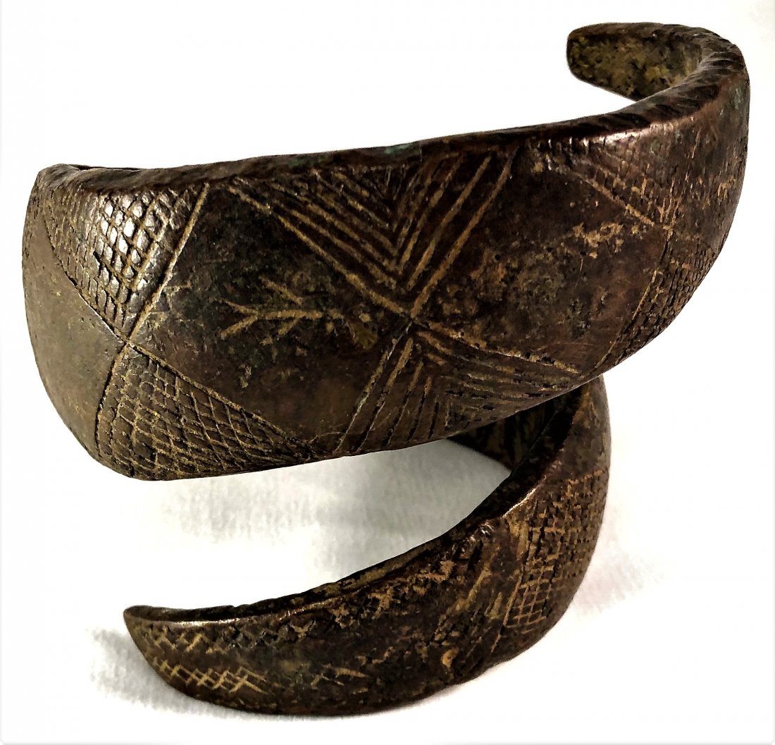 Ancient Benin Bronze Arm Band, Nigeria: Ancient Benin Bronze Arm Band, NigeriaAn early type, likely 16th, possibly 17th century, of coiled snake form, an upper arm band of punch and graved line decorated bronze. A court related embellishmen