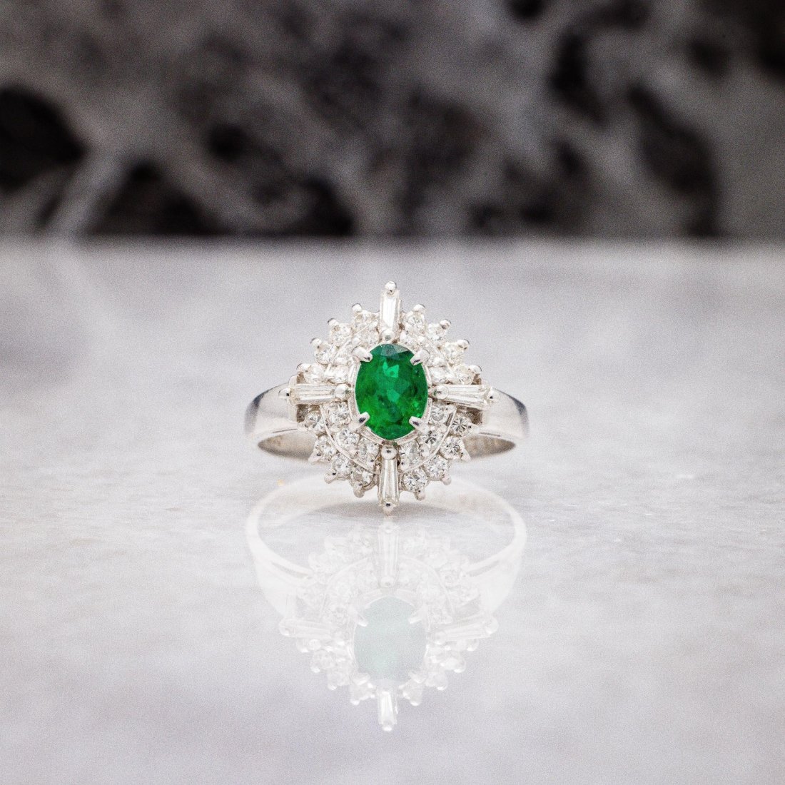 Vintage Platinum .97 ctw Emerald Diamond Halo Ring: A gorgeous ring with materials that match the quality craftsmanship. this ring features and oval shape bright green natural emerald gemstone surrounded by natural white diamonds. Can be worn as a fanc
