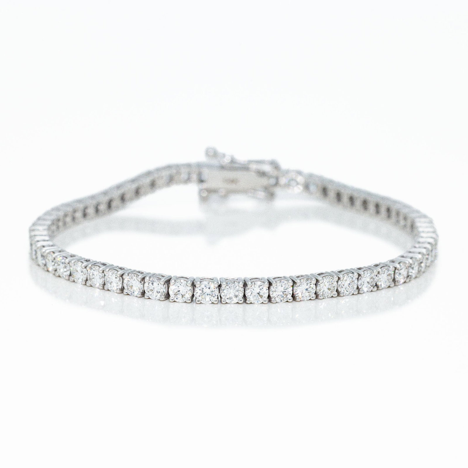 14kt White Gold 5.50 ctw Diamond Tennis Bracelet: A very fine tennis bracelet featuring round diamonds in a total of 5.5 carats total weight in true VS clarity F color quality and excellent cuts. The bracelet itself allows the diamonds to really shin