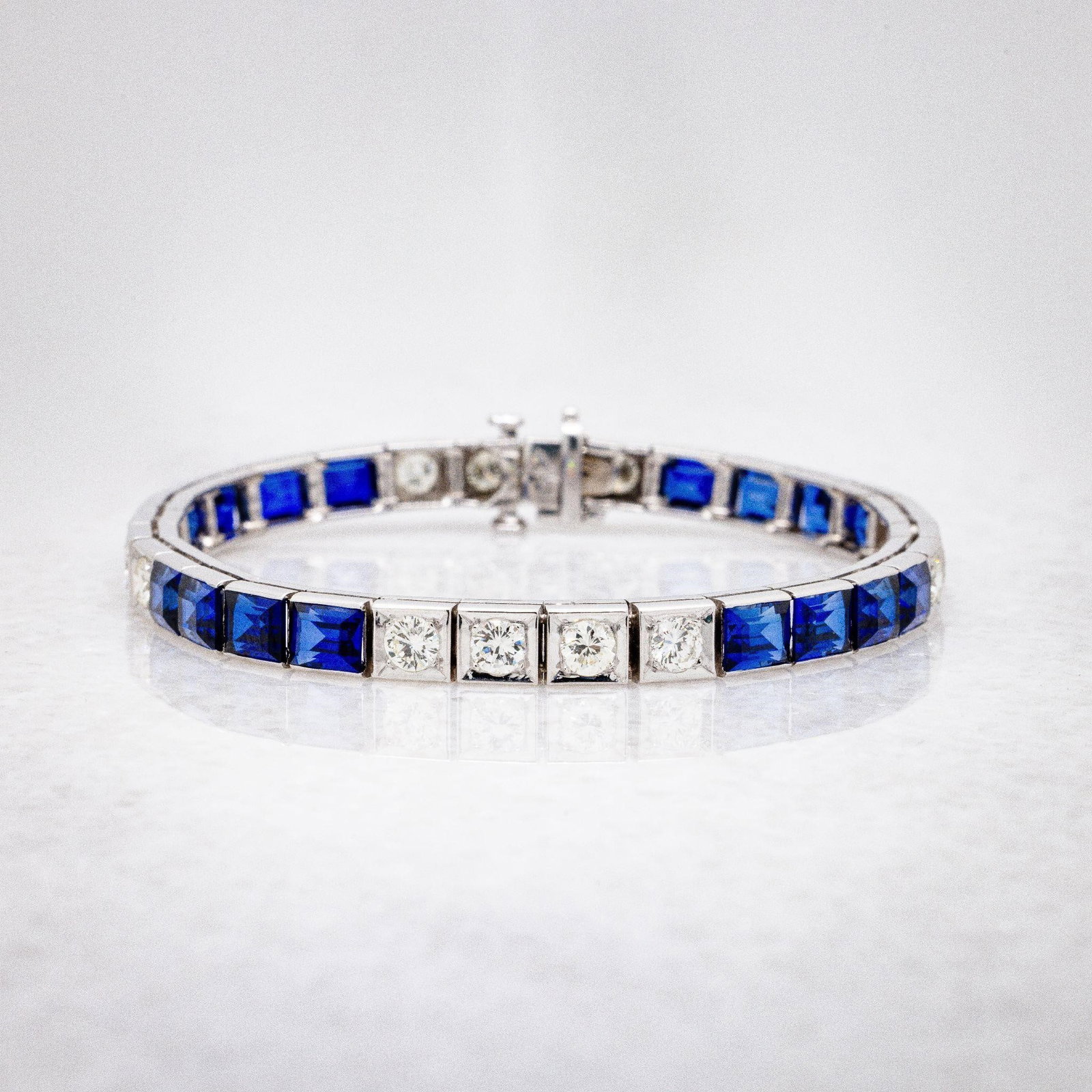 14kt WG Diamond Blue Sapphire 5mm Tennis Bracelet: A very fine bracelet crafted in 14kt white gold; natural diamonds and LAB grown blue sapphires. There is approx. 8 ctw of lab grown blue sapphires; 4 carats of natural white diamonds. The stones are