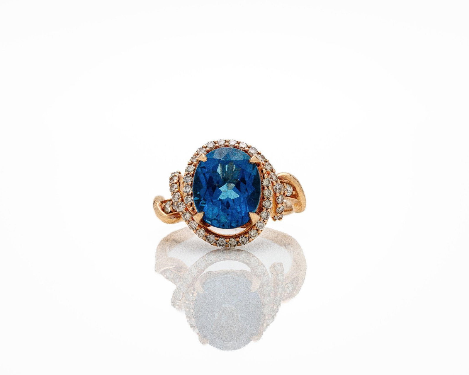 LeVian 14kt Rose Gold Blue Topaz Diamond Ring: Le Vian 14kt Rose Gold Blue Topaz & Diamond Ring A bold and elegant designer ring by Le Vian; centered on a richly colored oval-cut dark blue topaz measuring 12 x 10 mm; secured in a classic prong