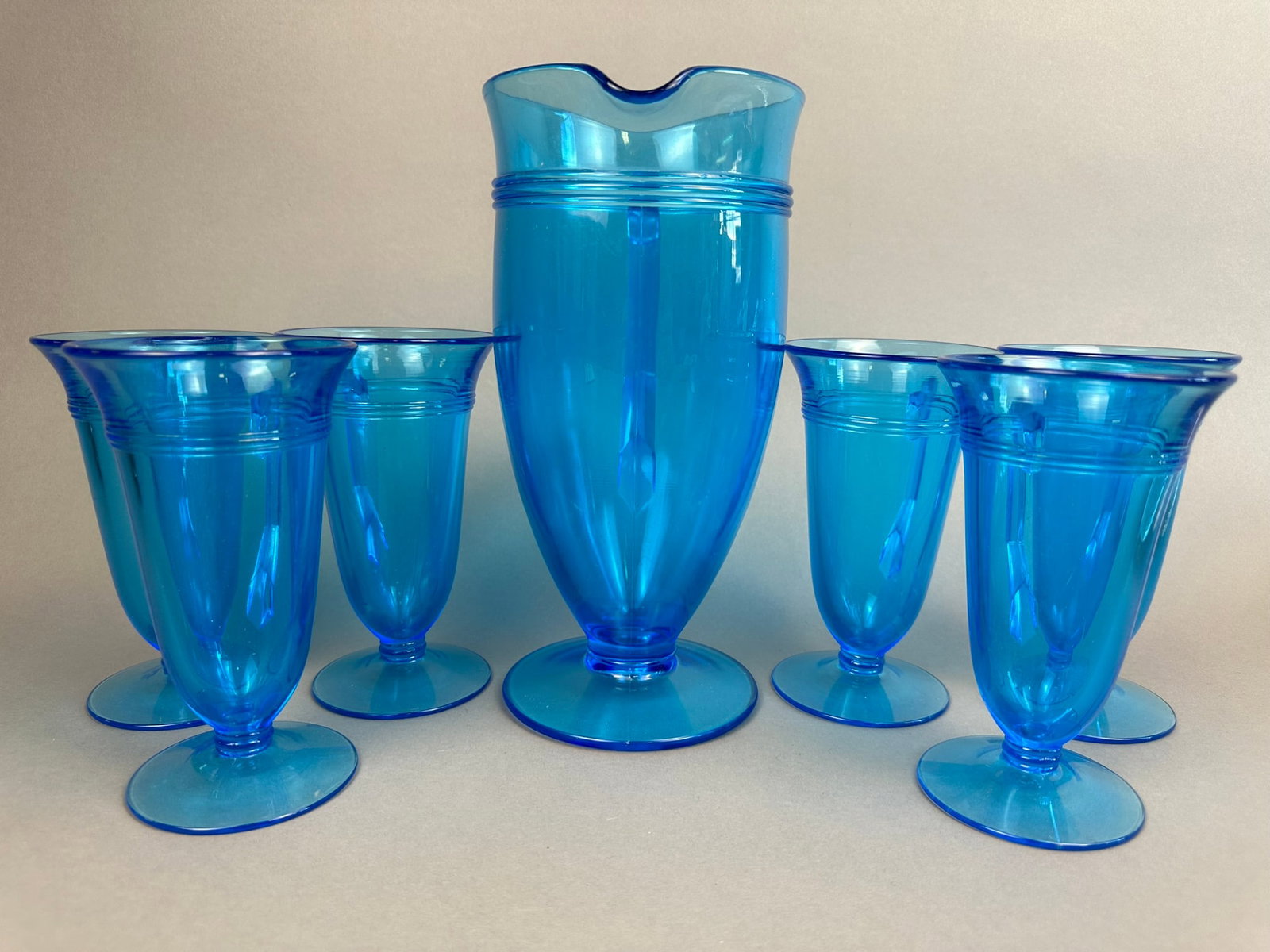 Antique Blue Fostoria Glass Pitcher 6 Glasses Set: This lot features a beautiful set of Fostoria in blue glass, pitcher and 6 matching glasses. All pieces are in excellent condition.